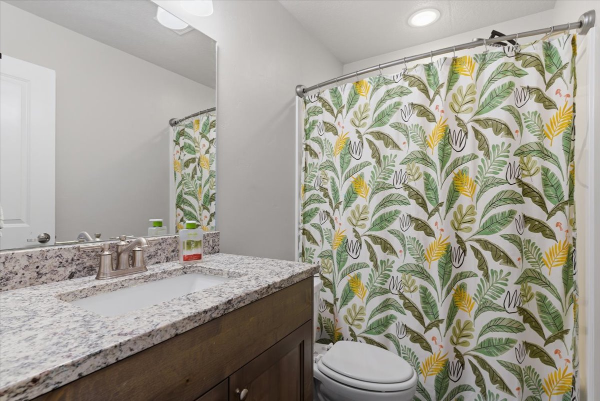 Bathroom vanity featuring a light-toned countertop with an integrated sink and a brushed nickel faucet