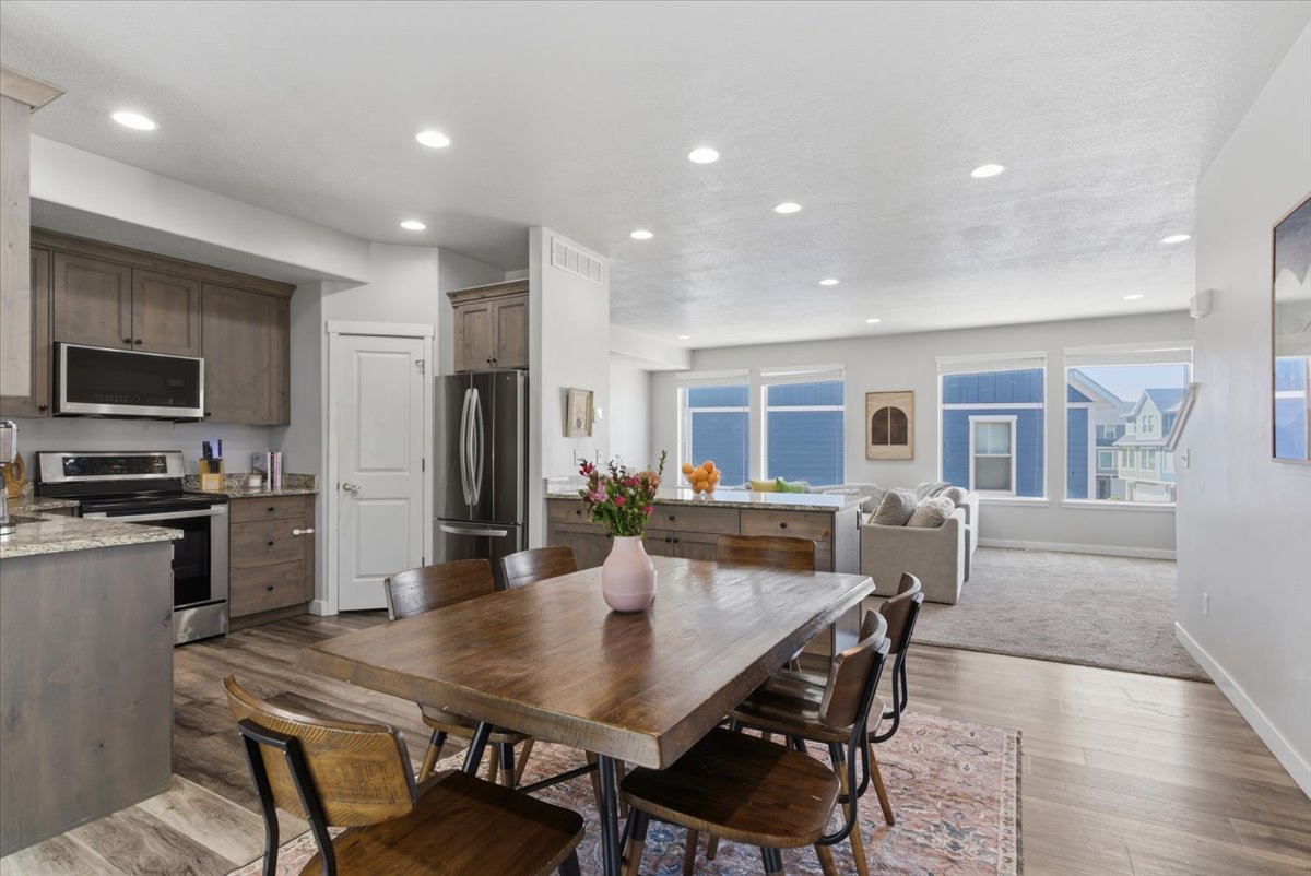 Open-concept living space featuring wood-finish flooring, recessed lighting, and large windows