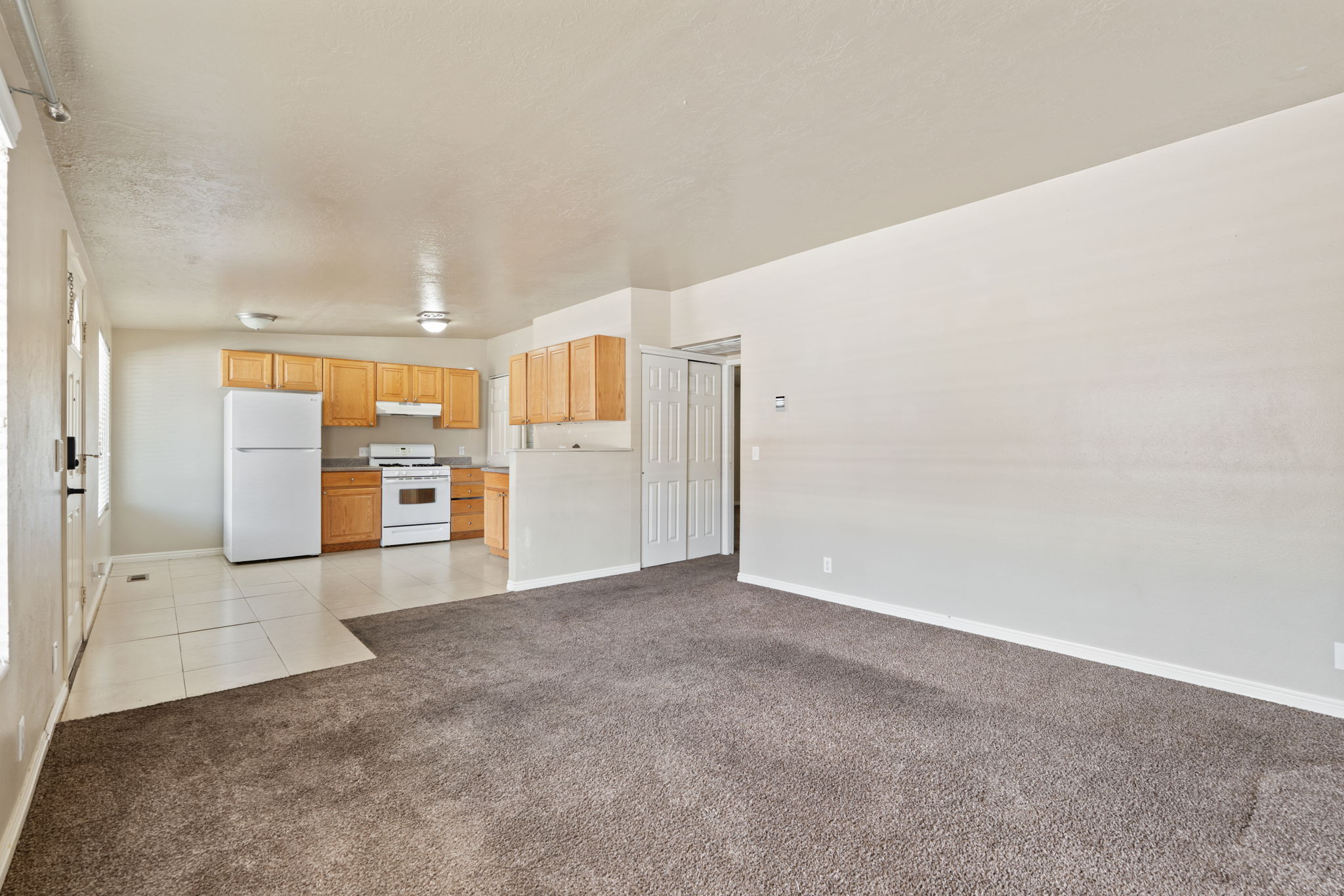 Open concept living area featuring textured carpeting