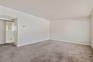 Spacious room featuring neutral carpeting and light-toned walls