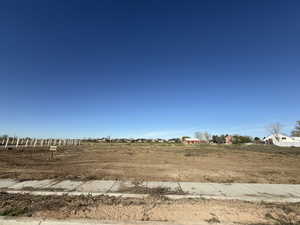 Expansive cleared lot with a newly installed concrete sidewalk and curb