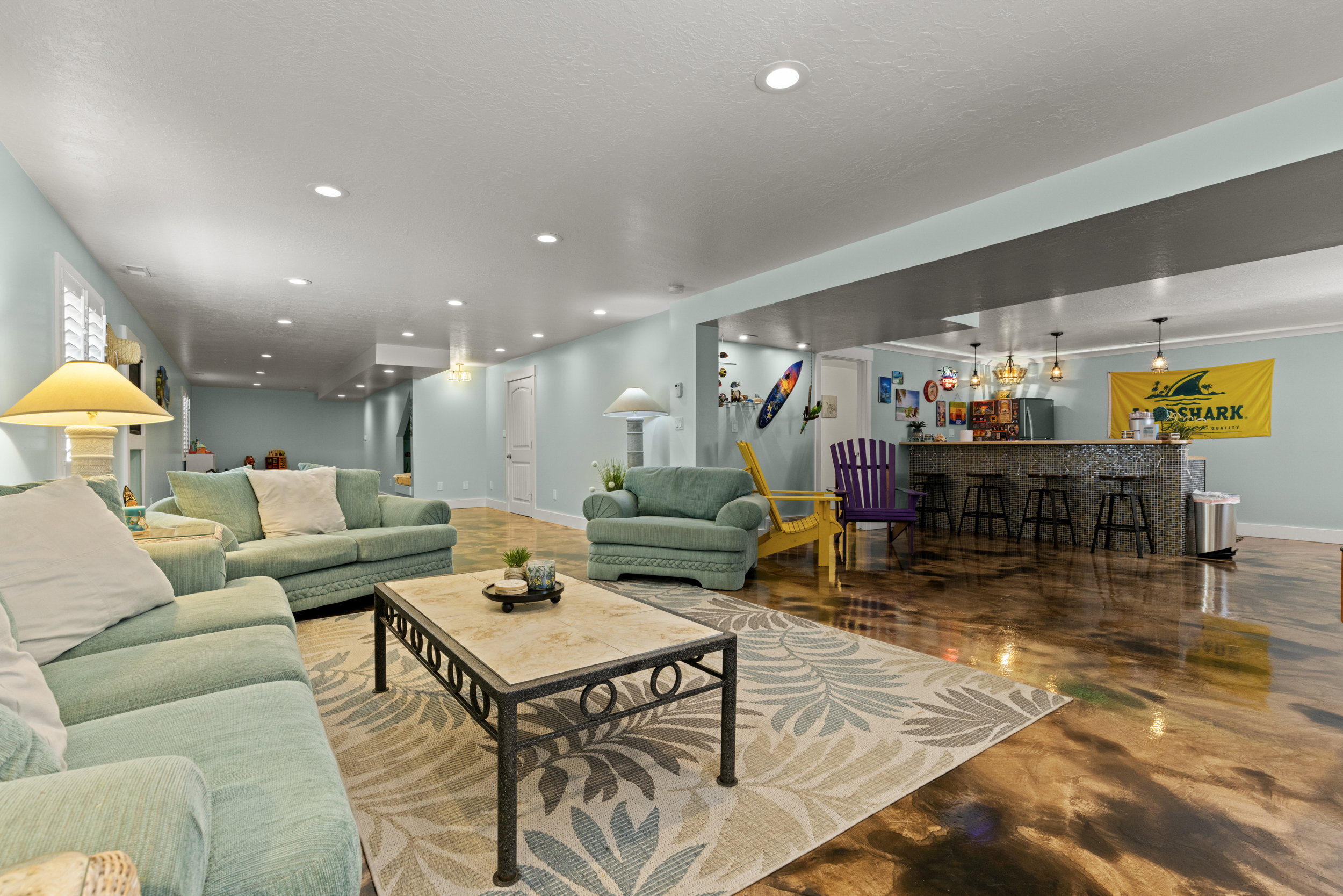 Expansive recreation room featuring a built-in bar with pendant lighting, a tile-finish bar front, and seating for four