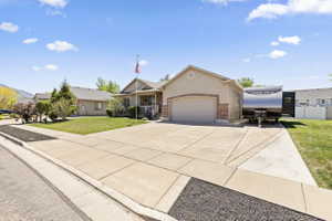 Single-story residence featuring a two-car garage with an arched opening, a brick facade accent, a covered front porch, and a concrete driveway