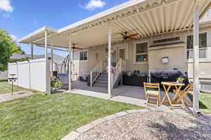 Expansive covered patio featuring a built-in ceiling fan, string lighting, and direct access to the interior