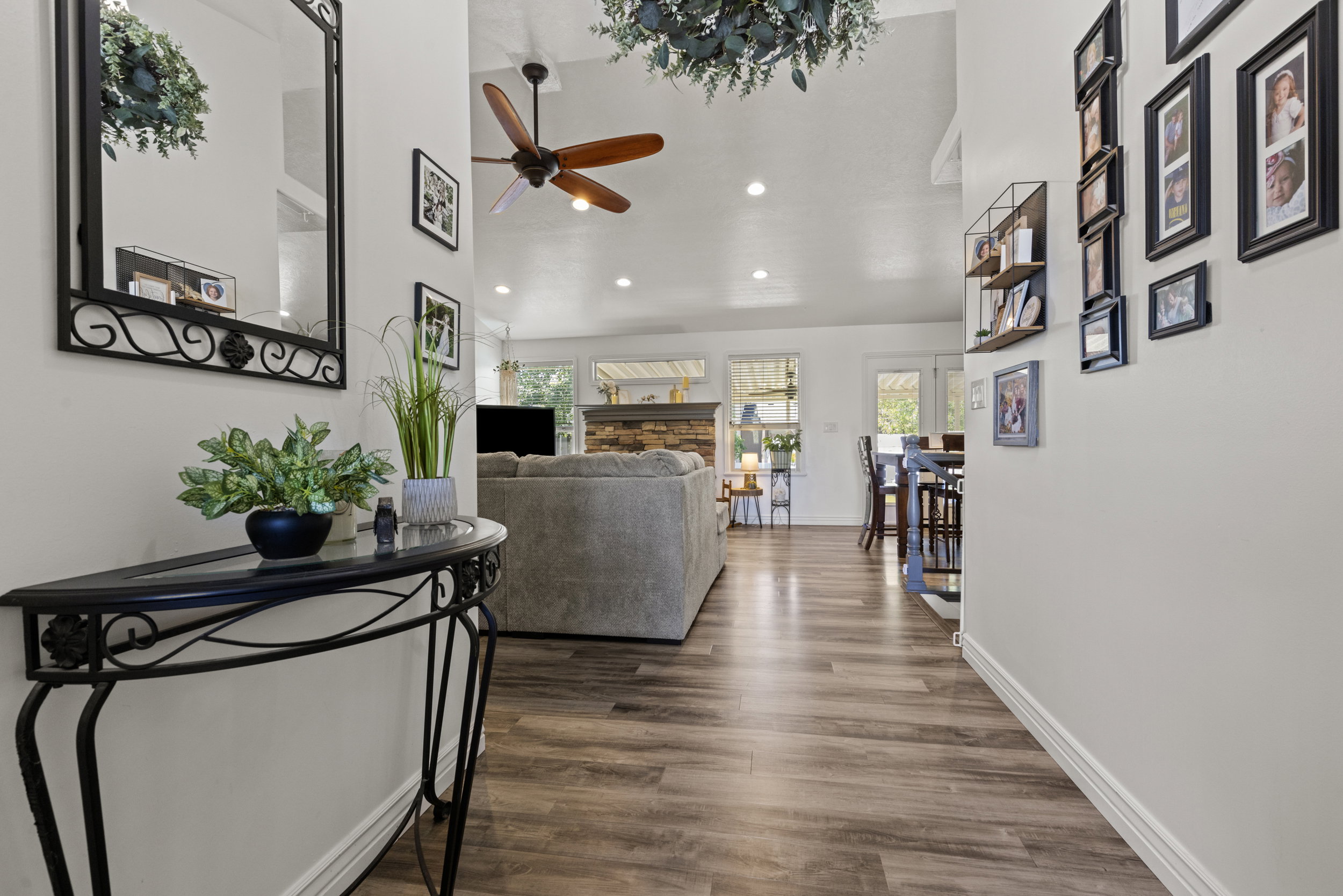 Open-concept living space featuring wood-finish flooring, vaulted ceilings, a ceiling fan, and recessed lighting