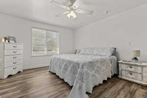 Bright interior space featuring wood-finish flooring, a large window with blinds, a ceiling fan with integrated lighting, and recessed ceiling lights