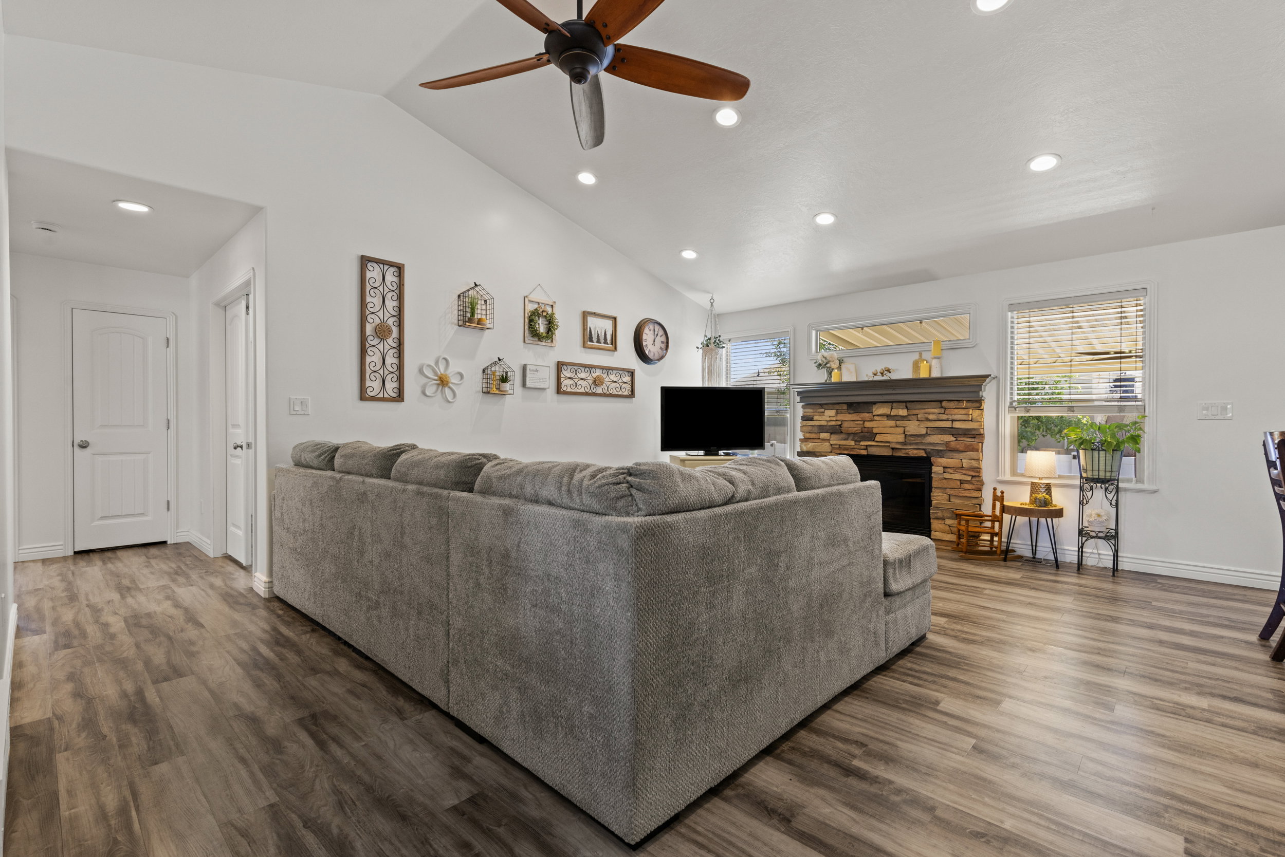 Spacious living area featuring wood-finish flooring, a vaulted ceiling, and recessed lighting