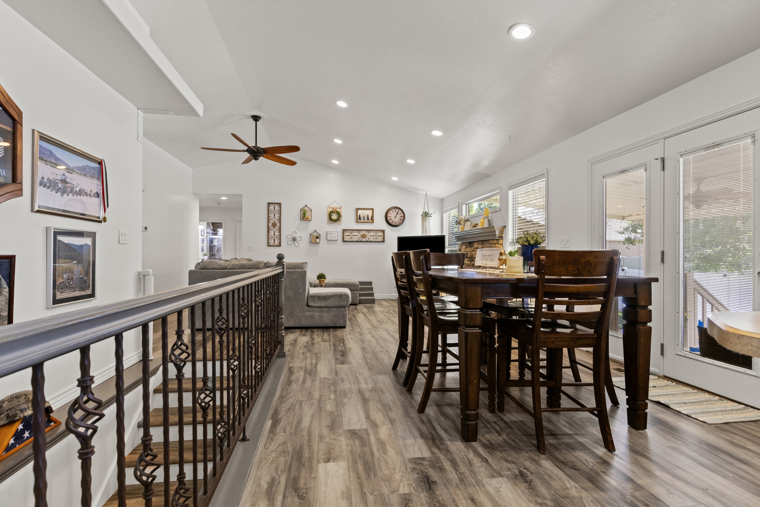 Open-concept living area featuring vaulted ceilings, recessed lighting, and wood-finish flooring