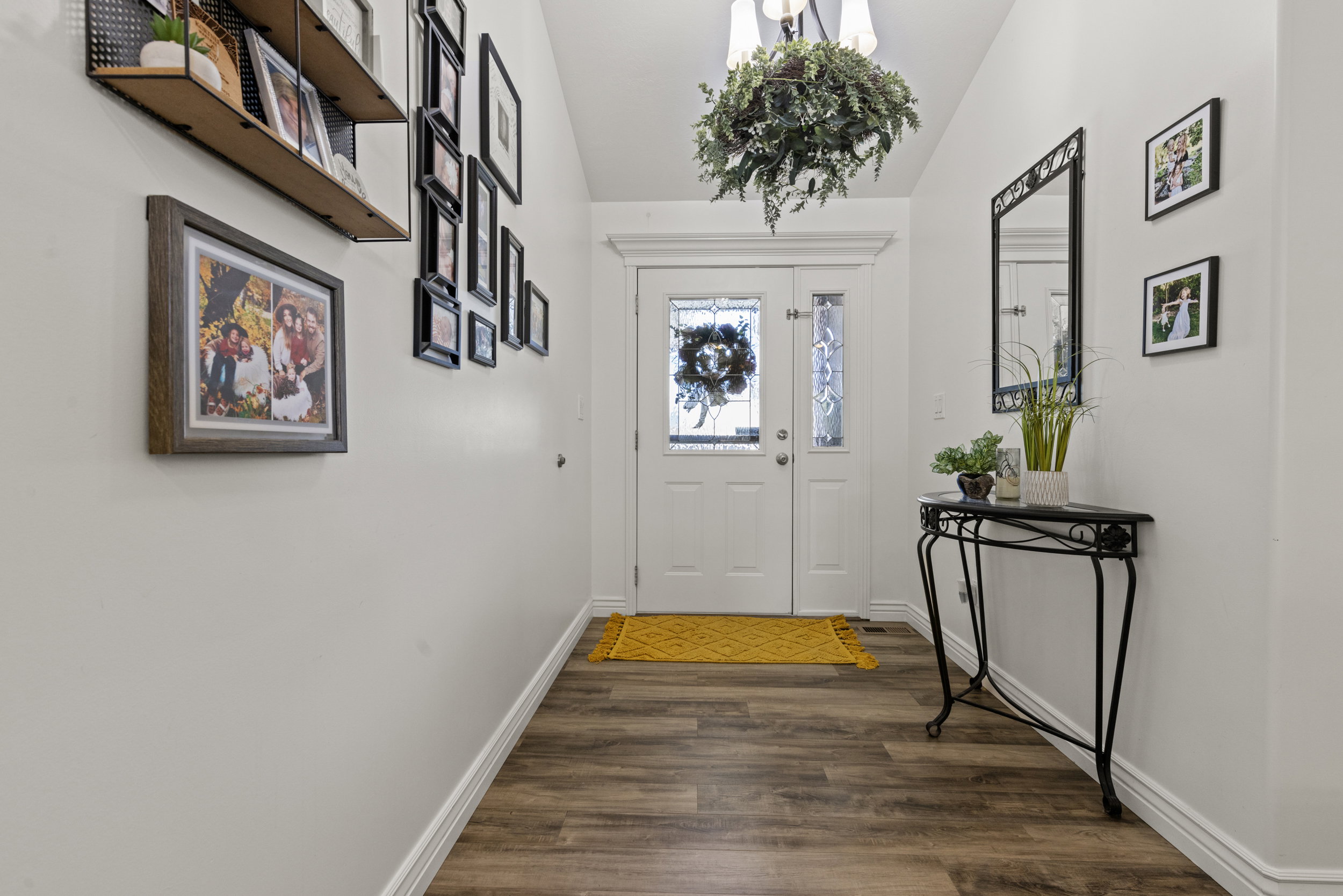 Entryway featuring wood-finish flooring, white baseboards, and a double entry door with decorative glass inserts