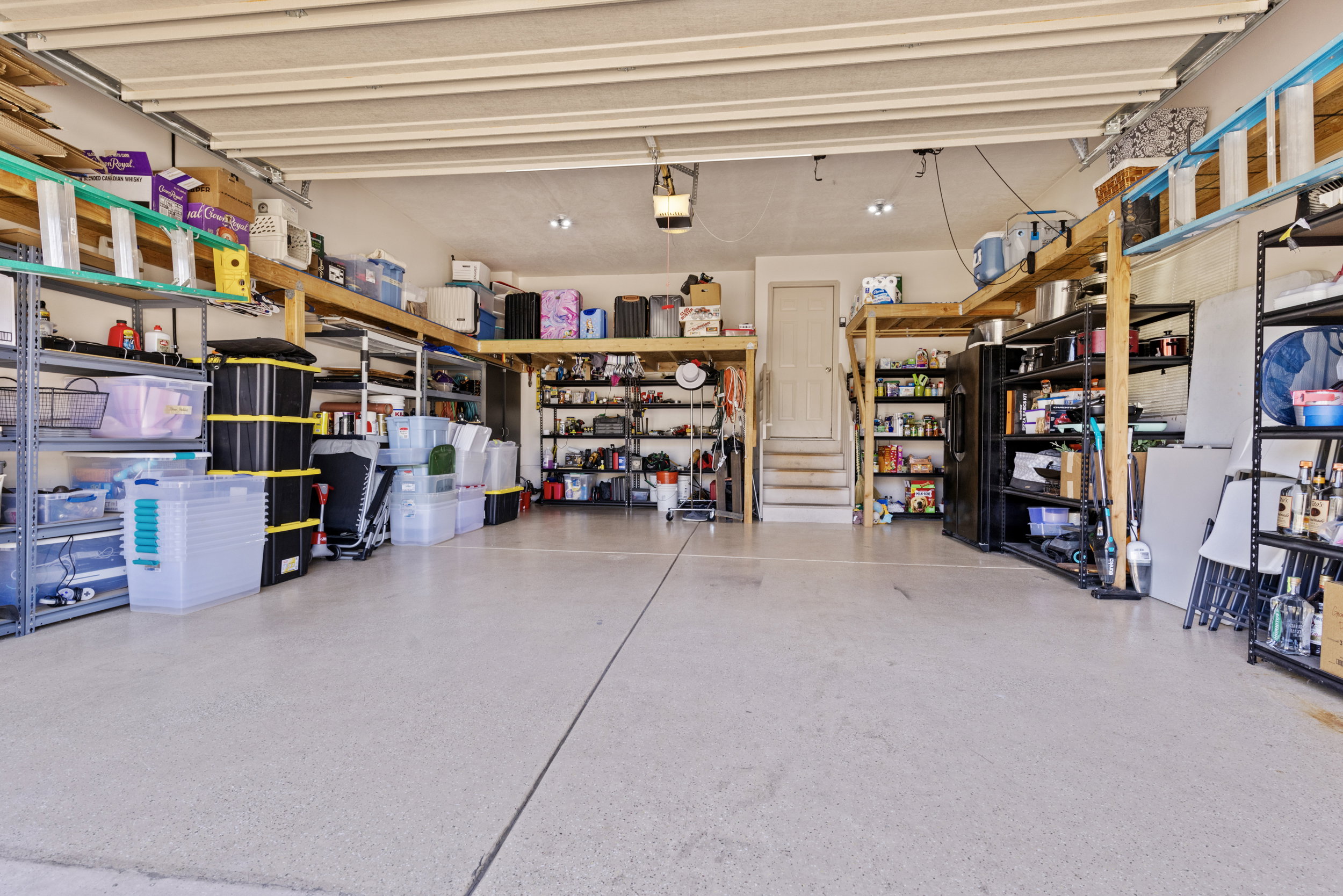 Spacious garage featuring a light-colored, speckled floor finish