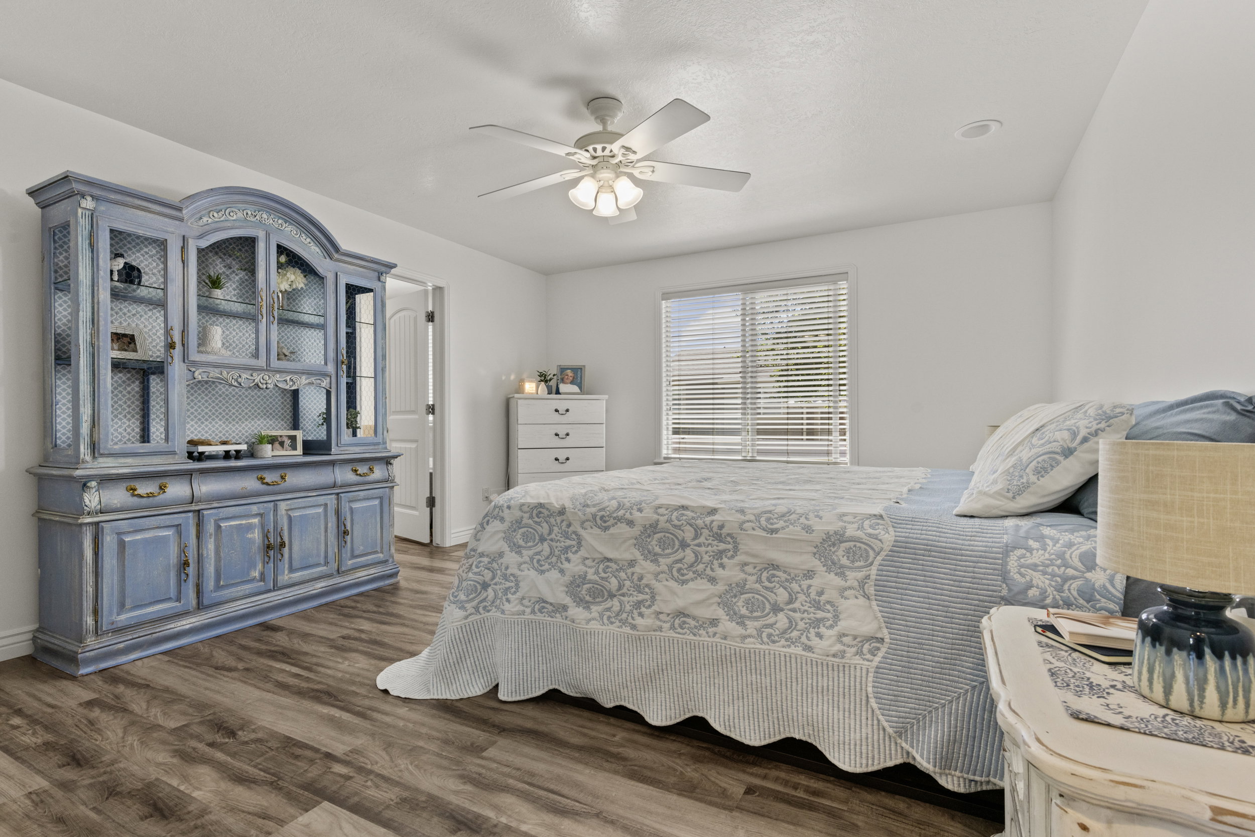 Spacious room featuring wood-finish flooring, a ceiling fan with integrated lighting, recessed lighting, and a window with horizontal blinds