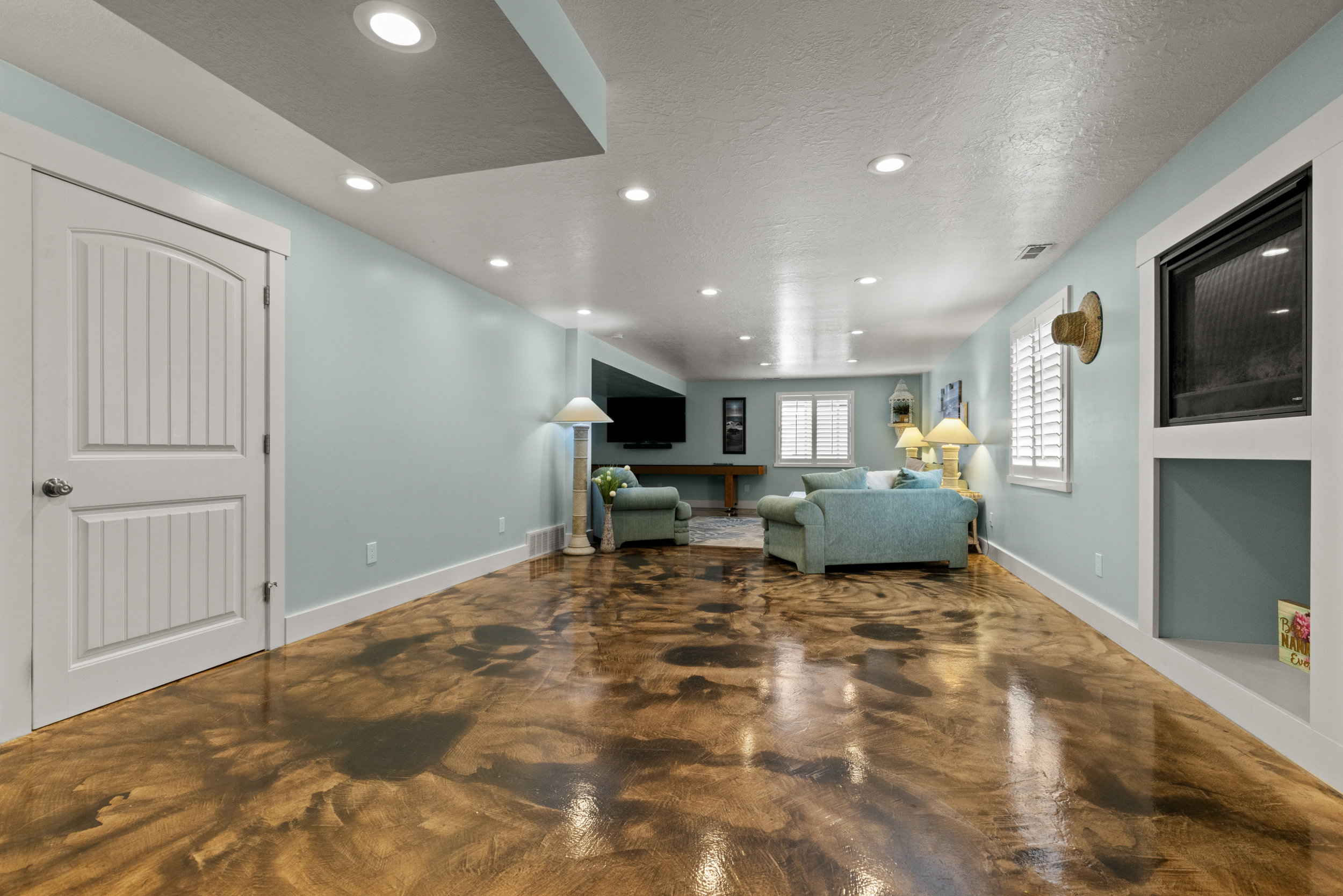 Expansive open-concept room featuring unique polished concrete flooring