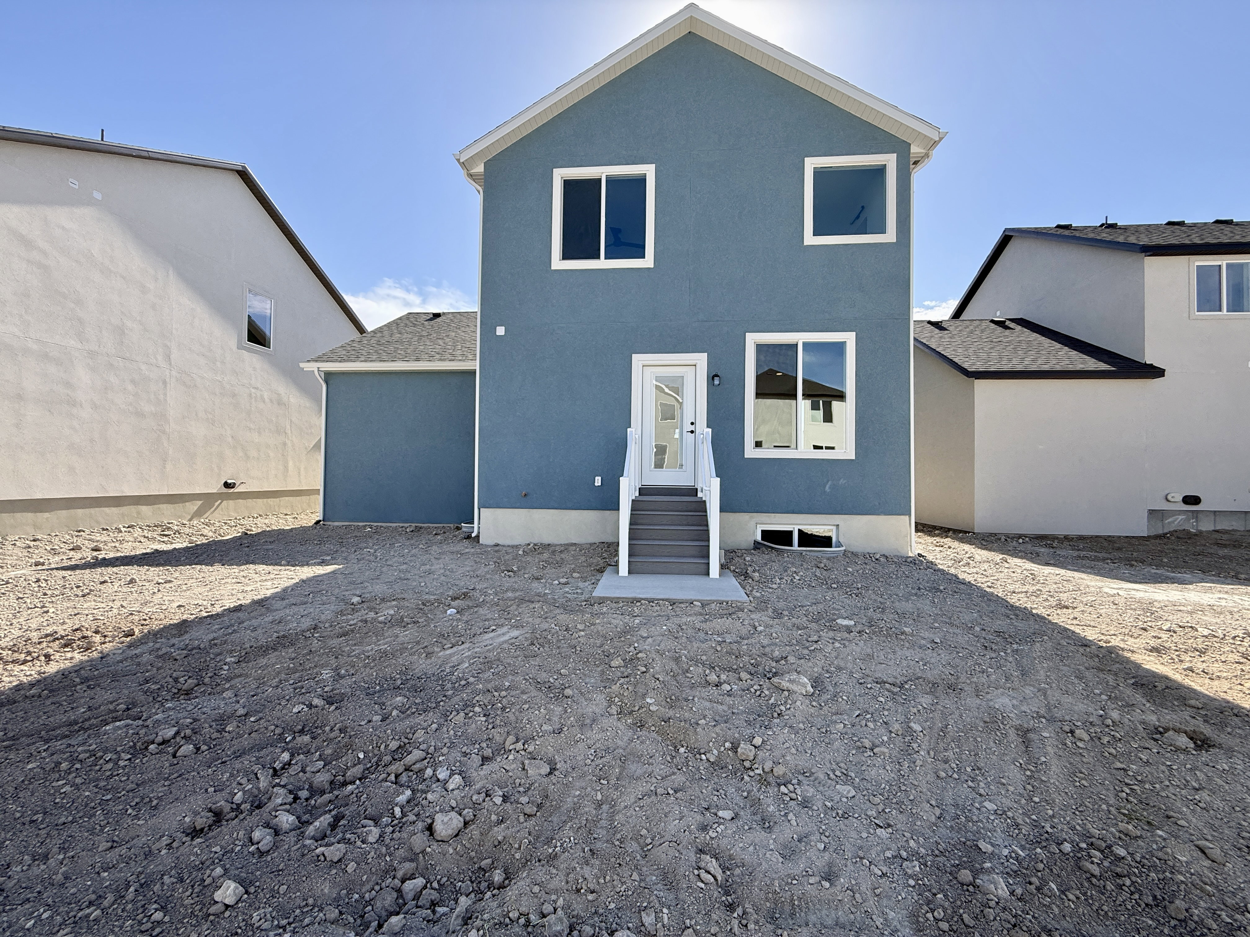 Rear exterior featuring blue stucco siding and white trim
