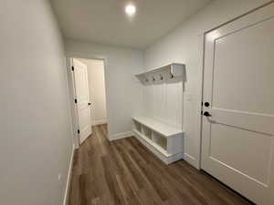 Entryway featuring a built-in bench with cubby storage, paneling, and coat hooks