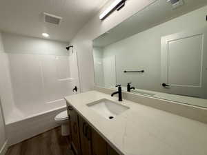 Bathroom vanity featuring a light-toned countertop with an integrated sink and matte black fixtures