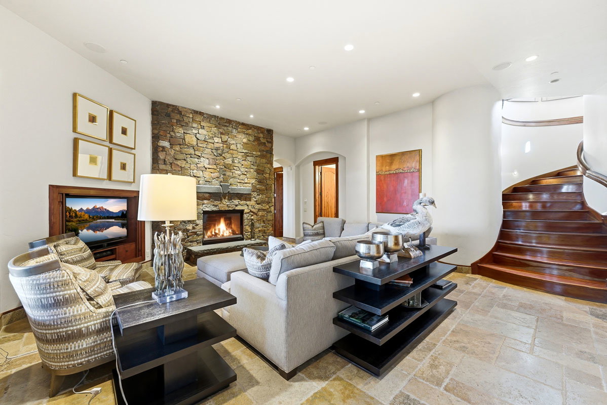 Stone-clad fireplace with a hearth, recessed lighting, and flagstone flooring