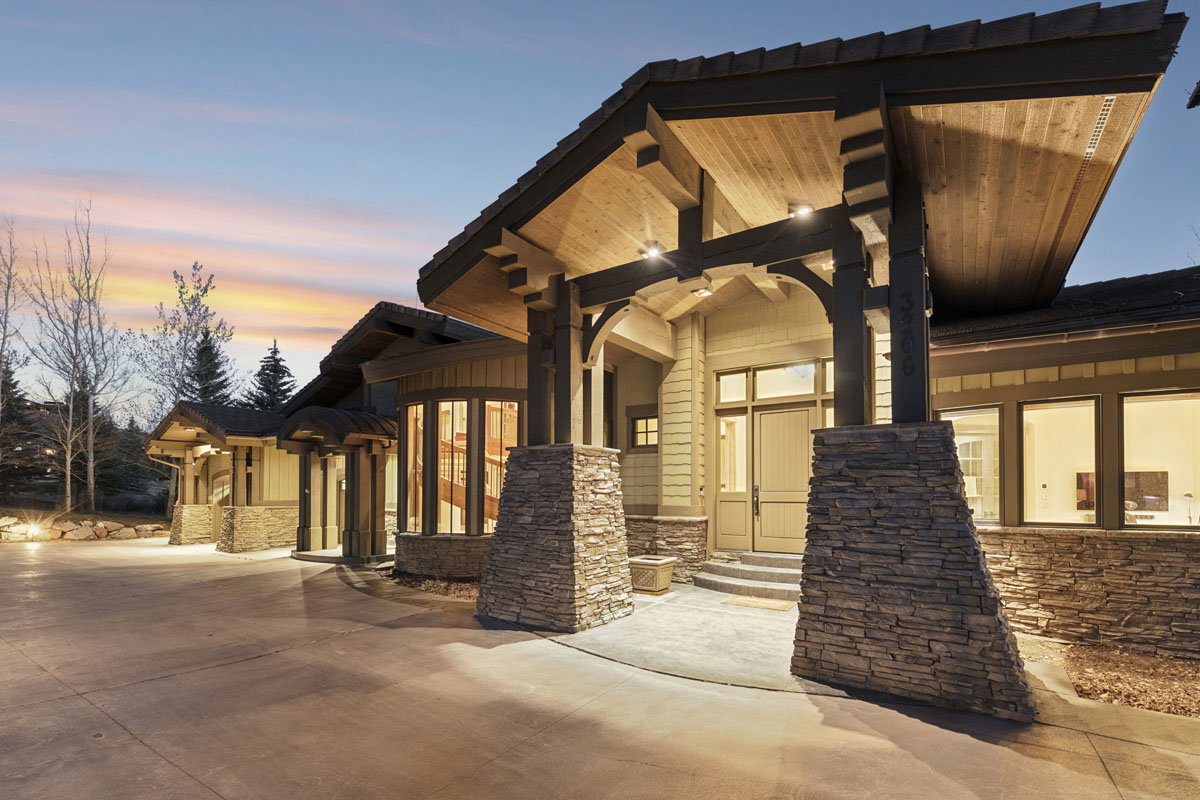 Stone and timber-frame entryway featuring a prominent porte-cochère with recessed lighting
