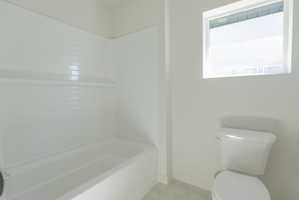 Full bathroom with a white bathtub and subway tile surround