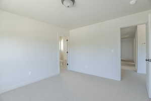 Carpeted interior room featuring light-colored walls and white trim