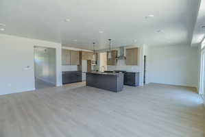 Open-concept living space featuring light wood-finish flooring, recessed lighting, and a kitchen with two-tone cabinetry