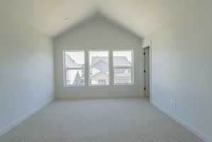 Room featuring a vaulted ceiling and three large windows