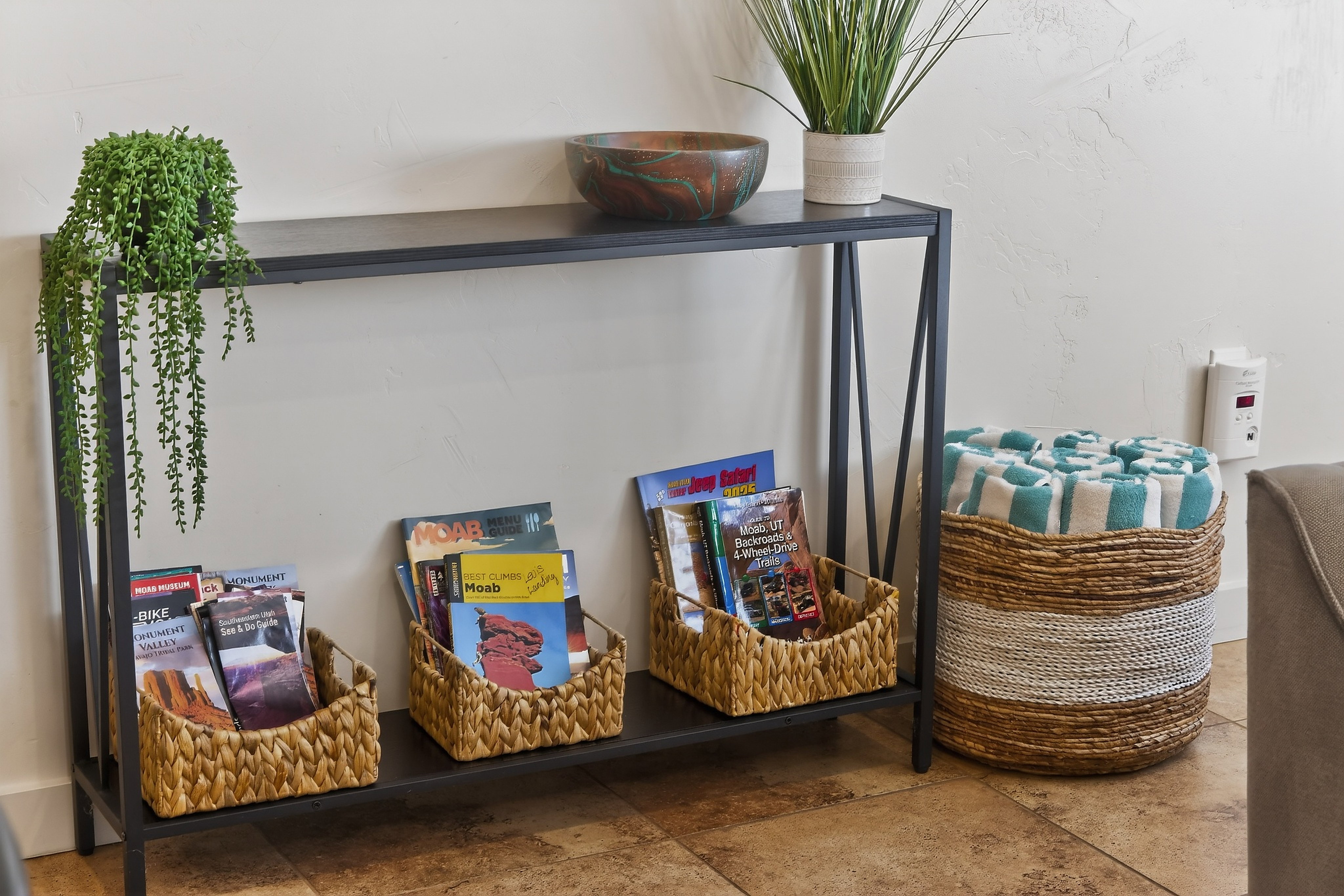 Iron-frame console table with a black finish, featuring a lower shelf and a textured wall finish
