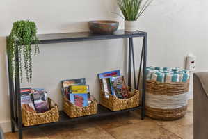 Iron-frame console table with a black finish, featuring a lower shelf and a textured wall finish