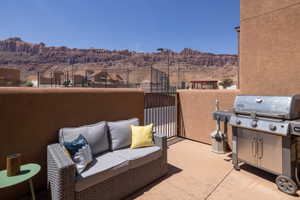 Private patio space featuring a concrete surface, stucco half-wall, and metal gate