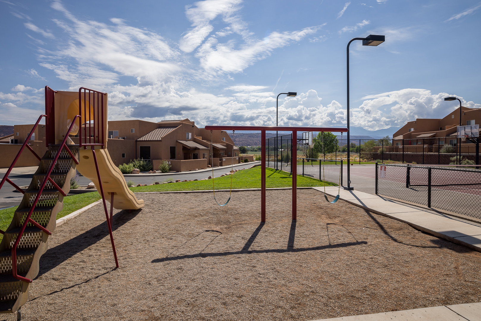 Playground area featuring a slide, swing set, and sand base