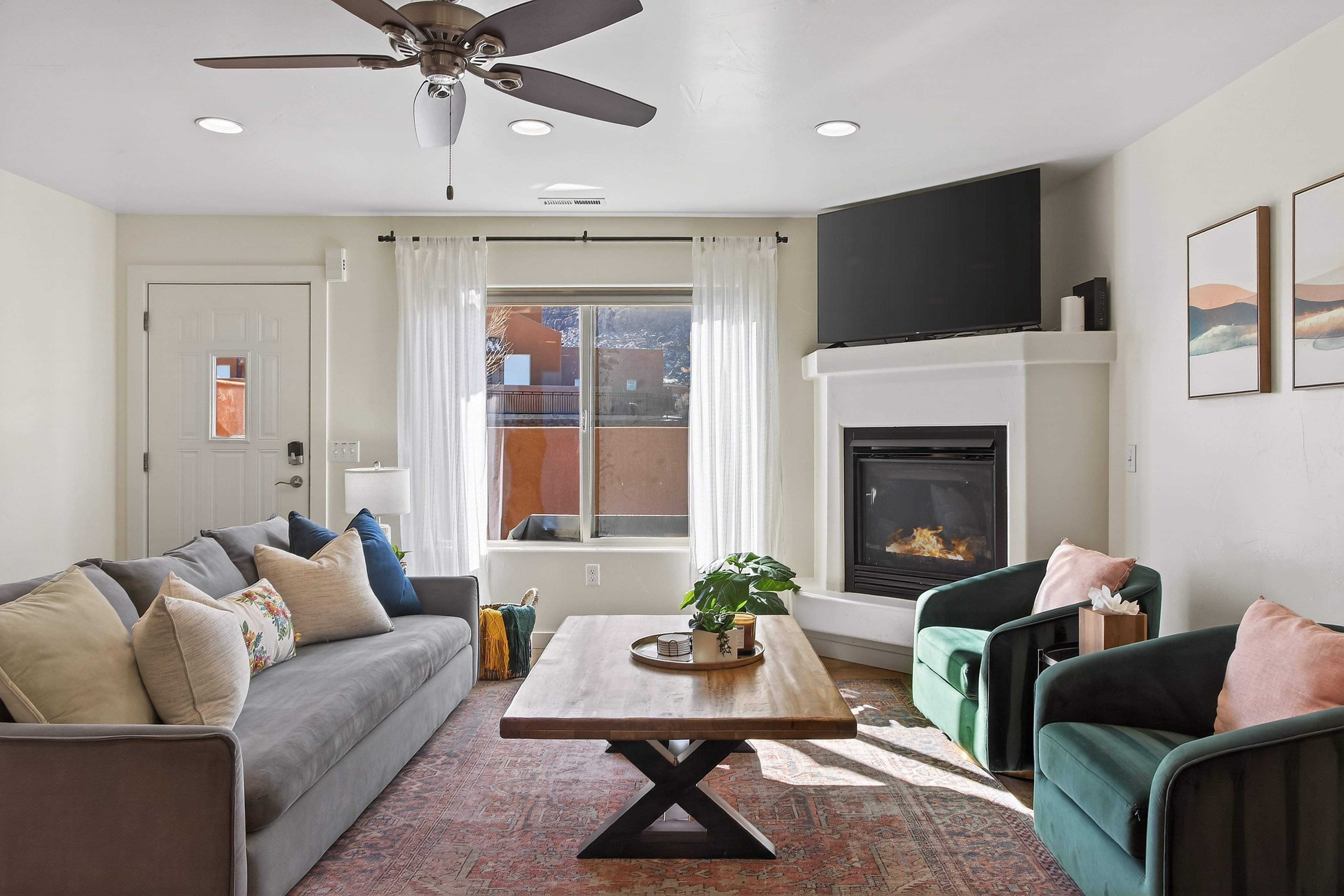 Living area featuring a corner fireplace with a white mantel, recessed lighting, and a ceiling fan