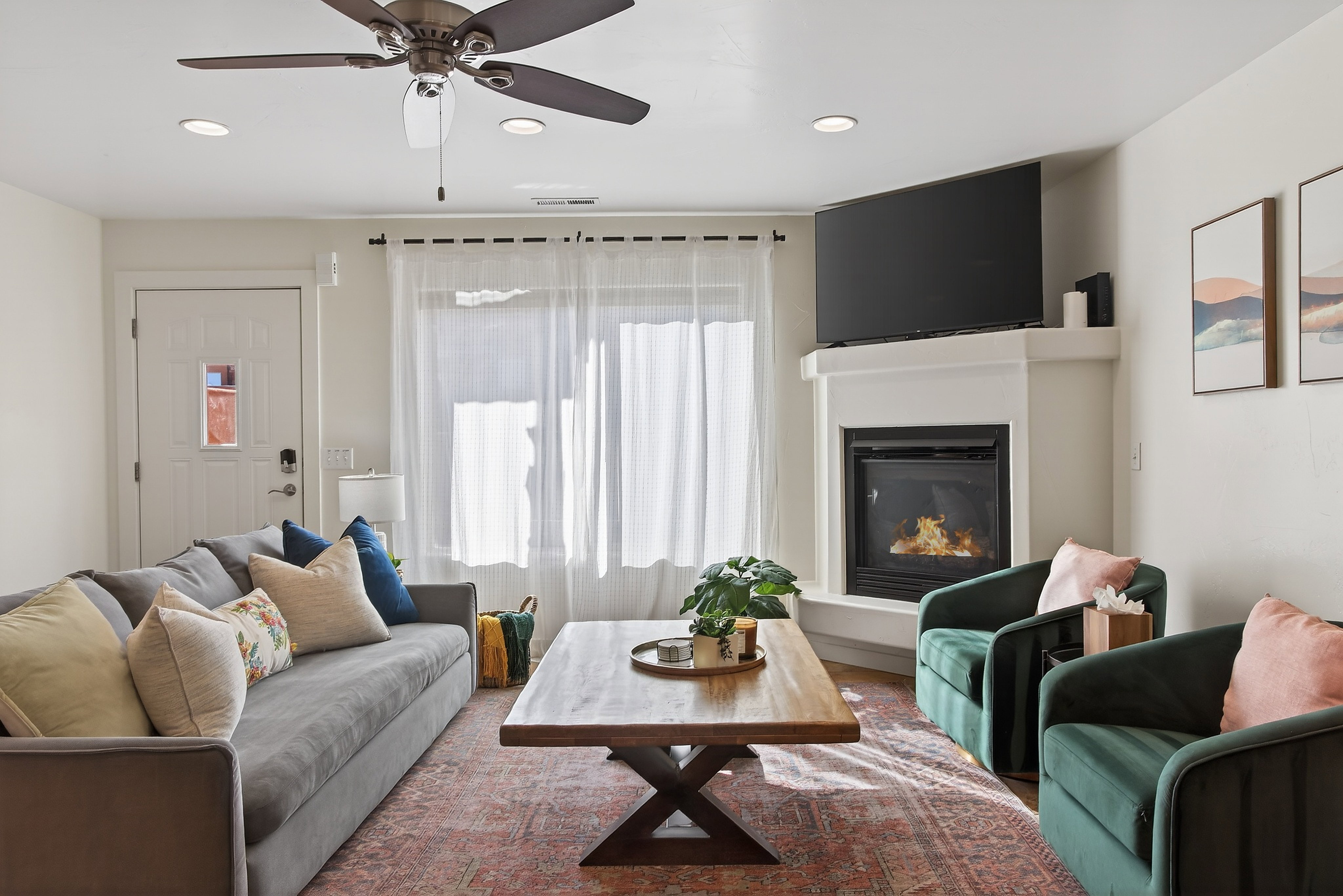 Living area featuring a corner fireplace with a white mantel, recessed lighting, and a ceiling fan
