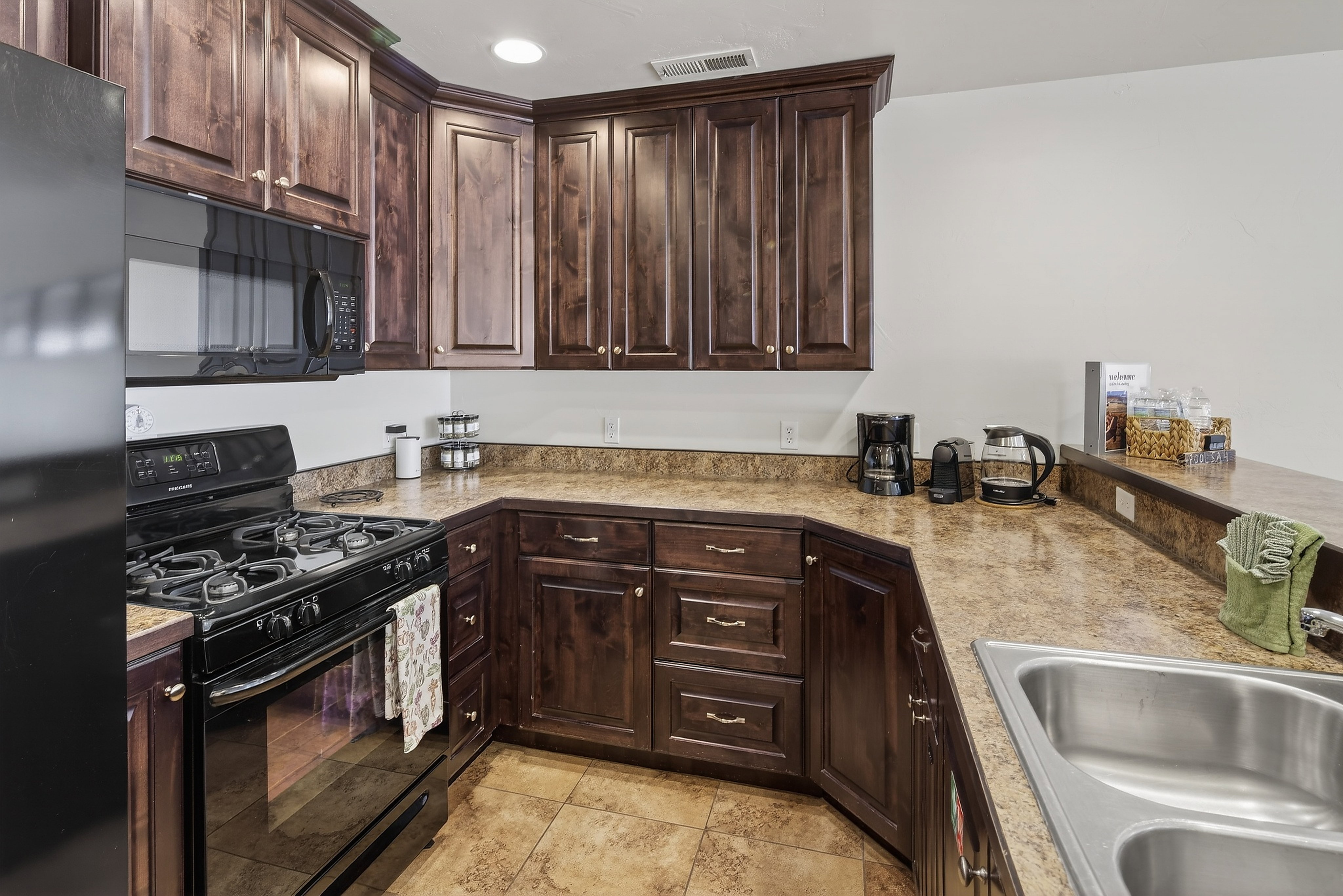 Kitchen featuring dark wood cabinetry and brown patterned countertops