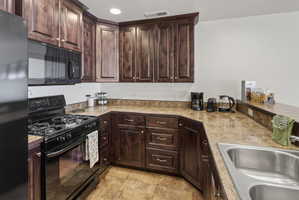 Kitchen featuring dark wood cabinetry and brown patterned countertops