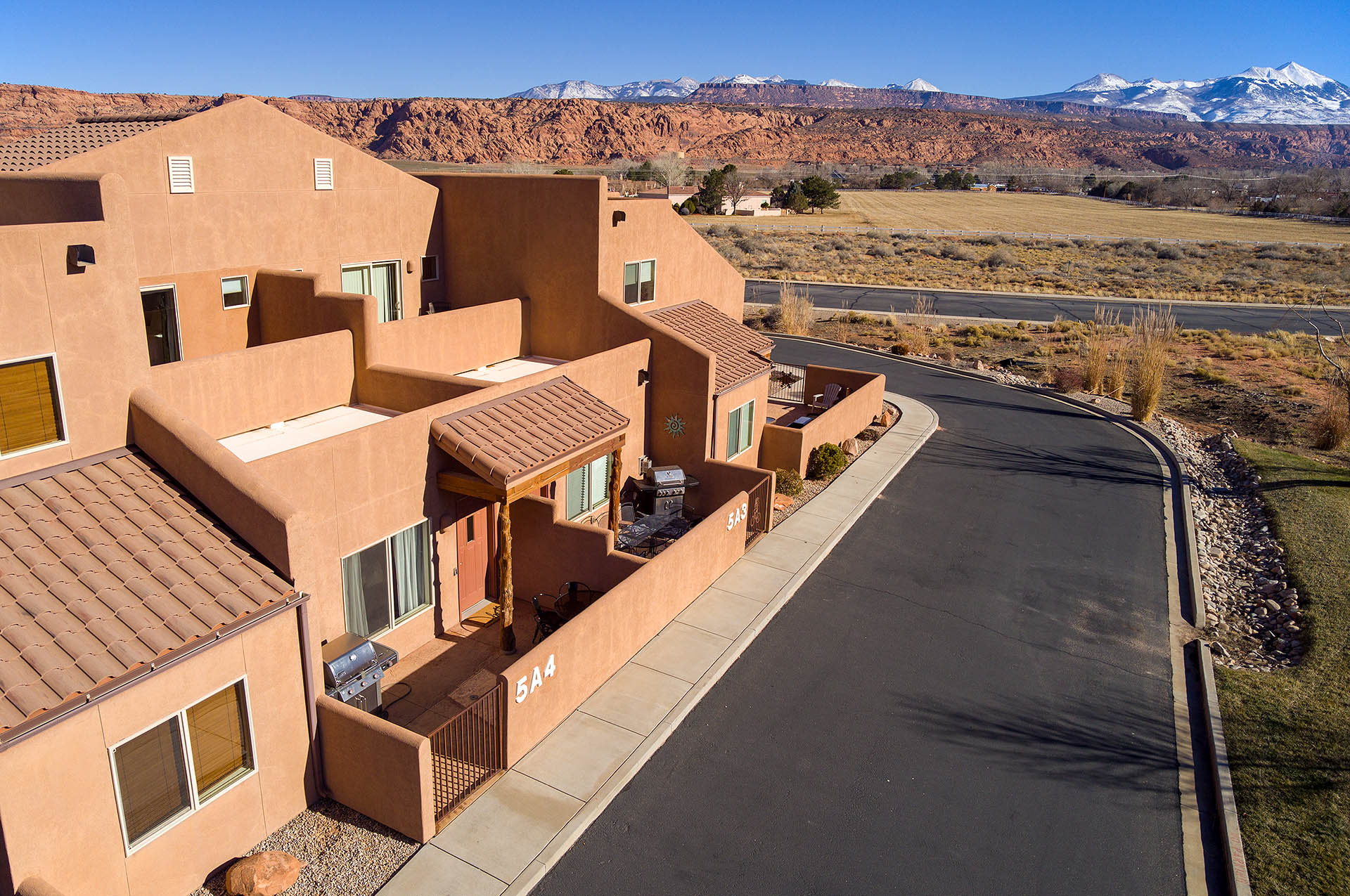 Southwestern-style stucco exteriors featuring tile roofs, private patio spaces, and individual entryways