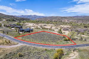 Expansive land parcel featuring natural shrubbery and established roadway frontage