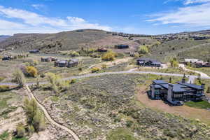 Expansive hillside landscape featuring a contemporary residence with a flat roofline, extensive window arrays, and multiple balconies