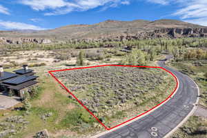 Expansive vacant lot featuring natural desert landscaping and a paved road frontage