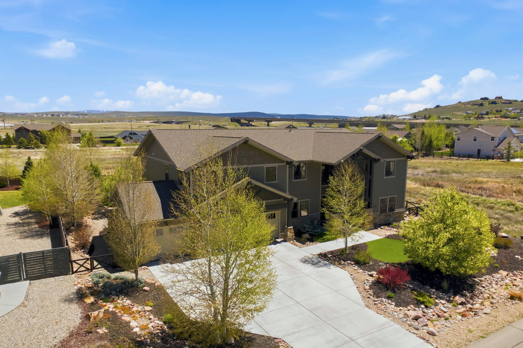 Contemporary two-story residence featuring a neutral-toned exterior, a concrete driveway, and a fenced side yard