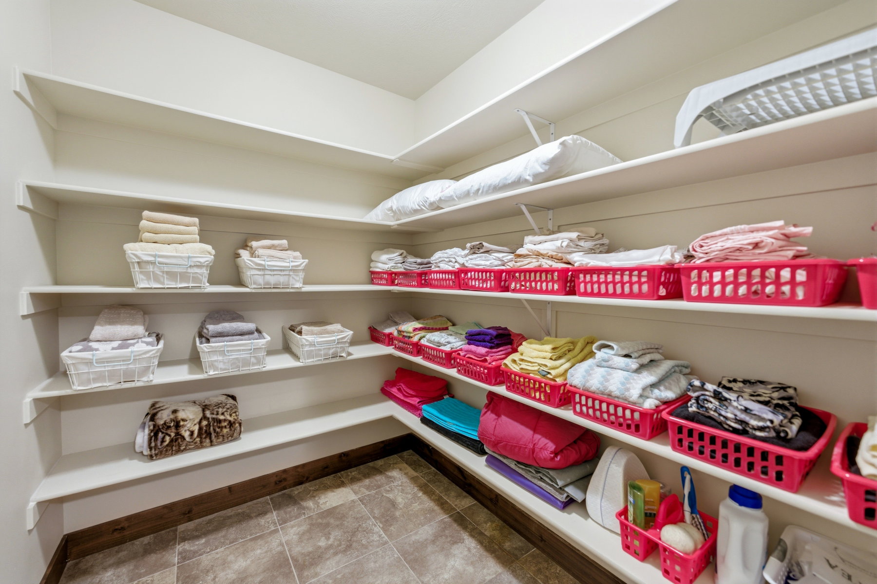 Built-in shelving unit providing extensive storage, featuring a tiled floor and a perimeter wood-finish baseboard