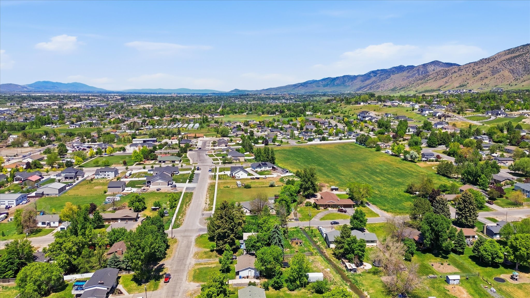 Expansive aerial landscape highlighting a residential area with varied housing styles and abundant green spaces