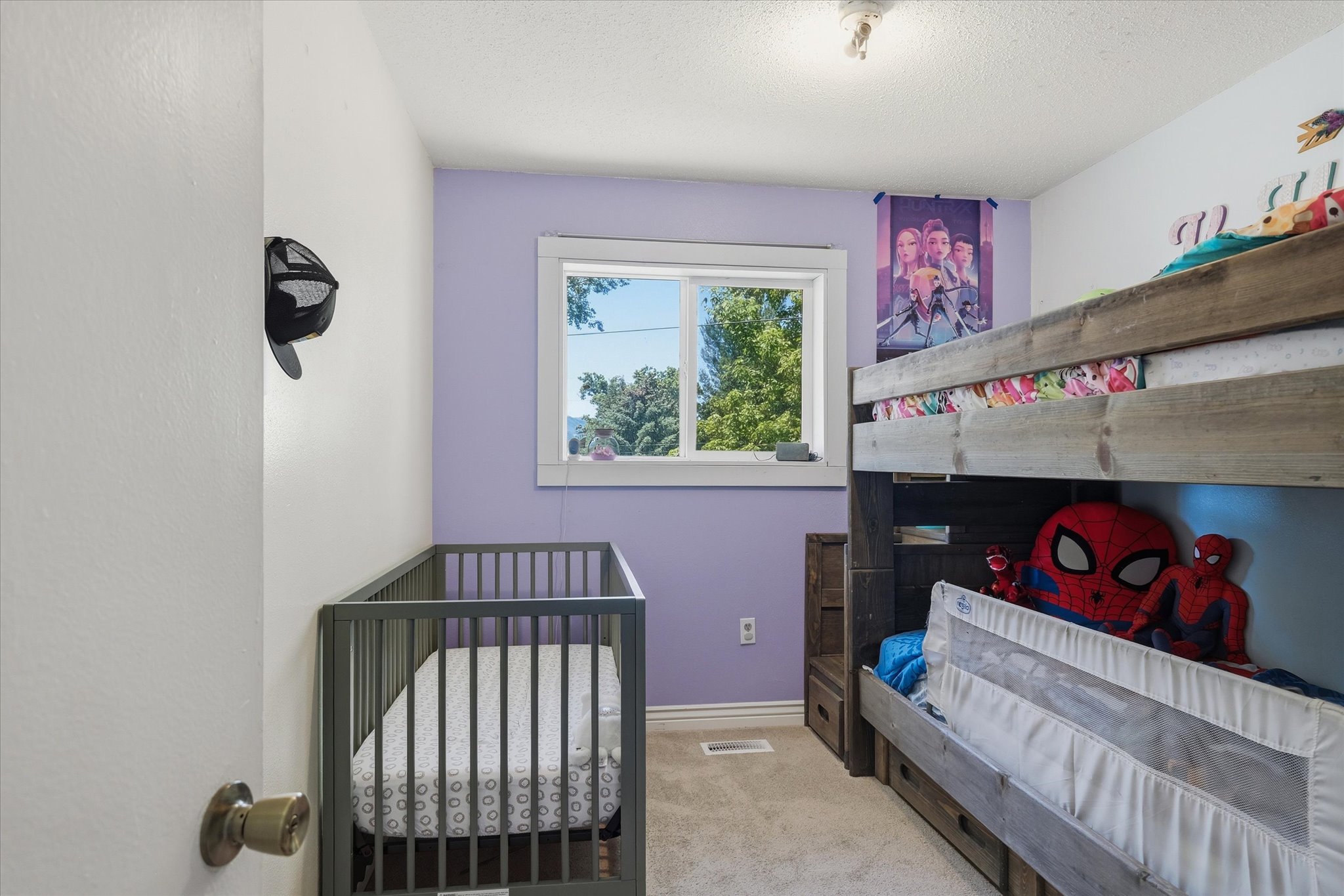 Bedroom featuring a white framed window, plush carpet flooring, white baseboards, and a ceiling-mounted light fixture