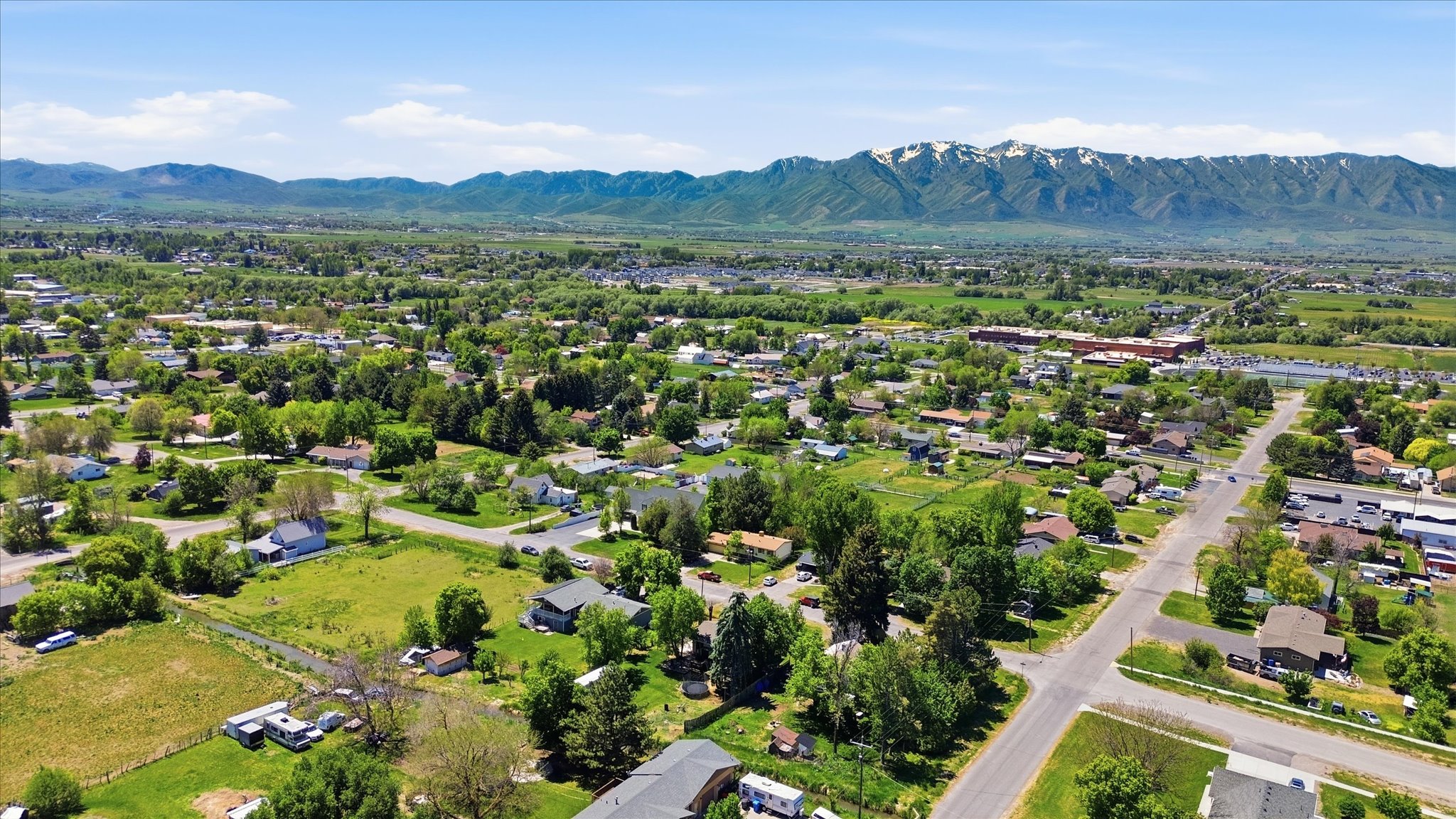Expansive aerial view showcasing a residential area with a prominent mountain range backdrop