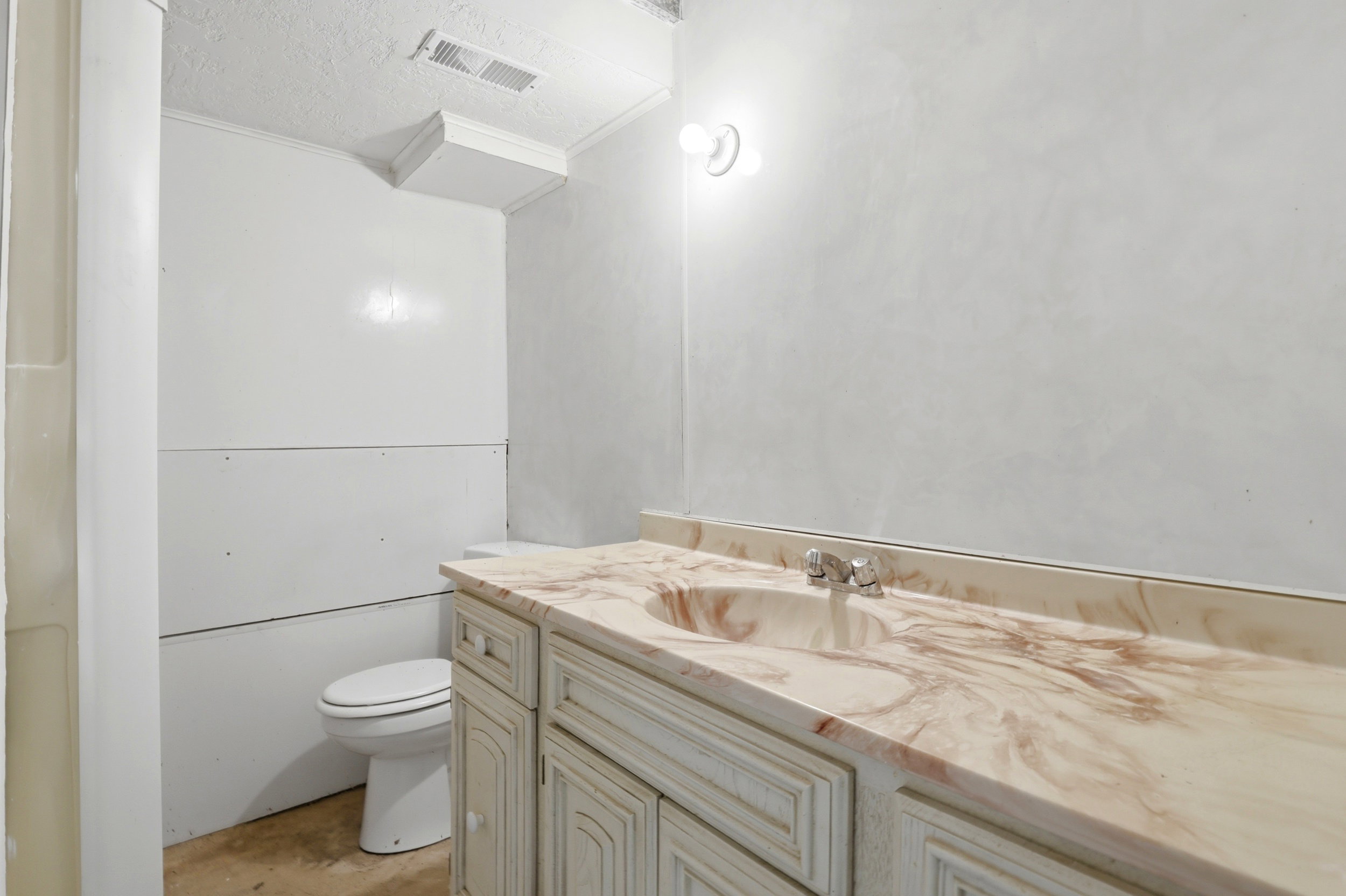Bathroom vanity featuring a marbled countertop with an integrated sink and chrome faucet