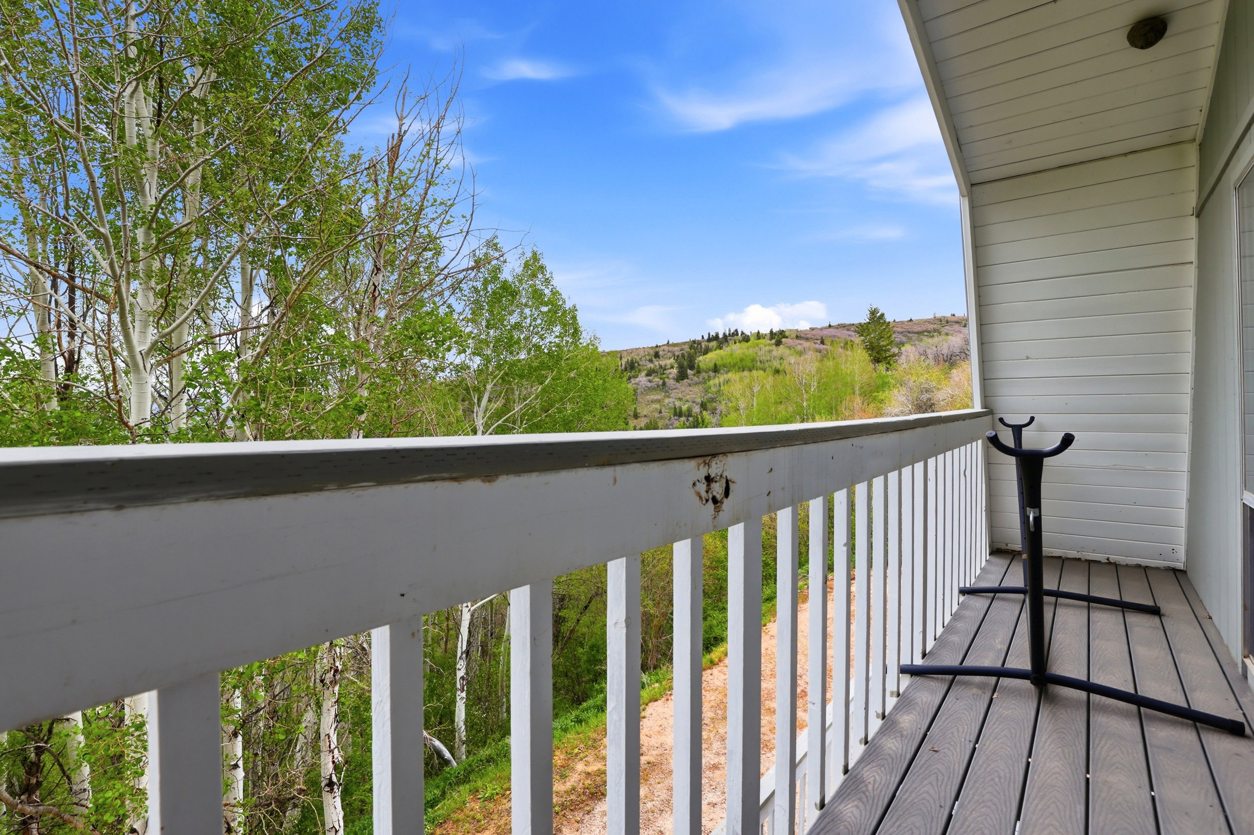 Private balcony featuring a wood-finish deck and white railing