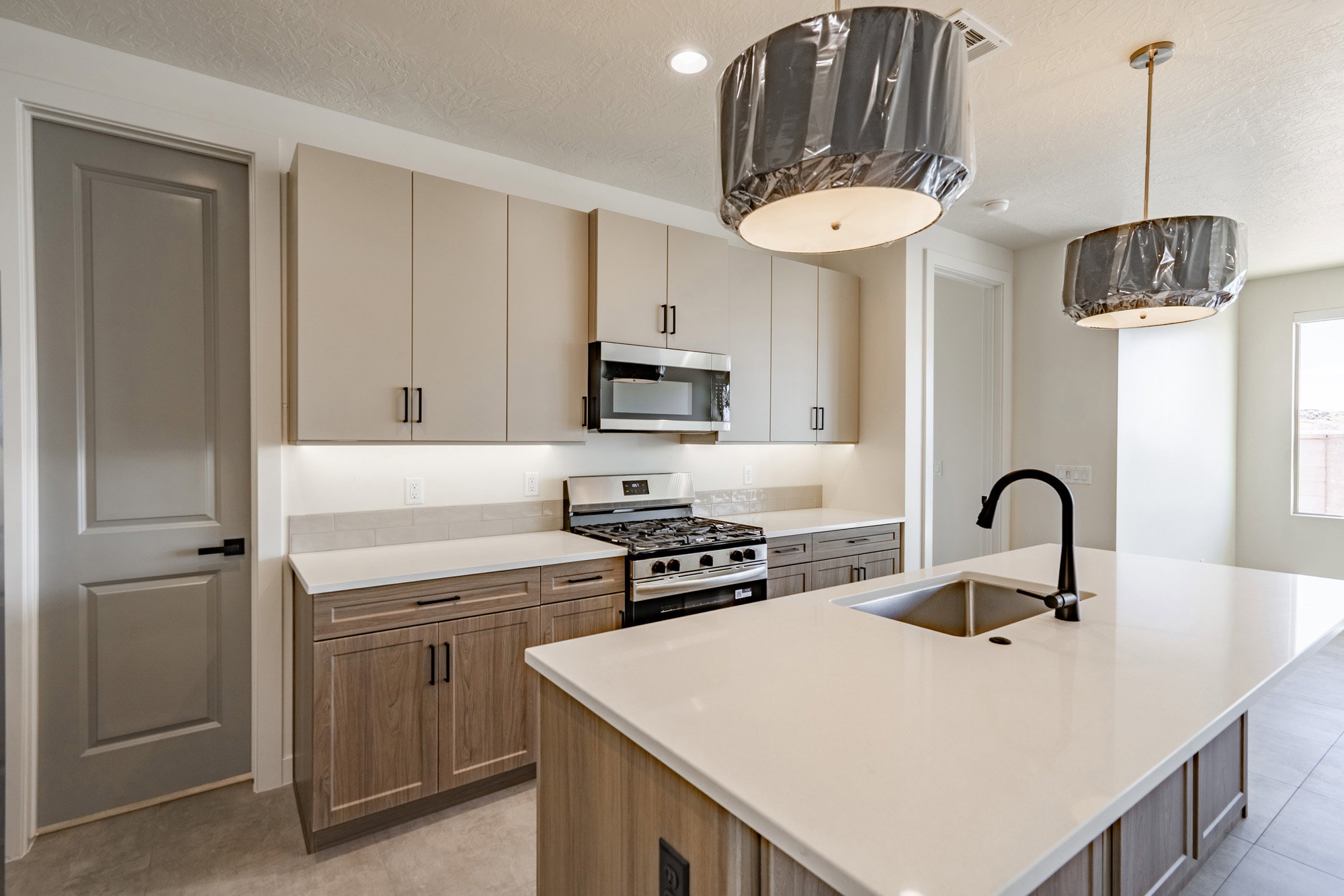 Kitchen featuring a large island with an undermount sink and black gooseneck faucet