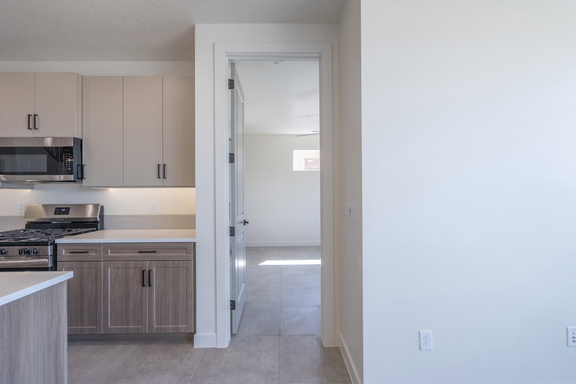 Modern kitchen with light-colored upper cabinetry and wood-finish lower cabinetry