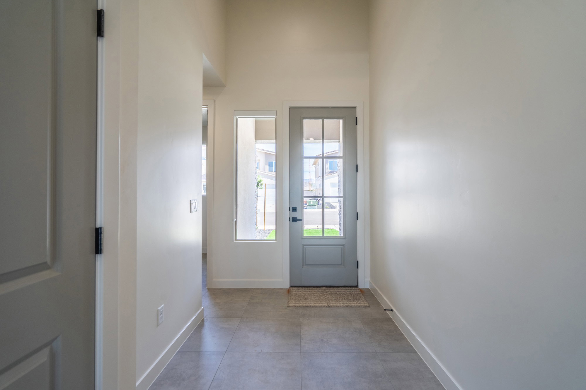 Entryway featuring a grey paneled door with multiple glass lites, a transom window, and a sidelite