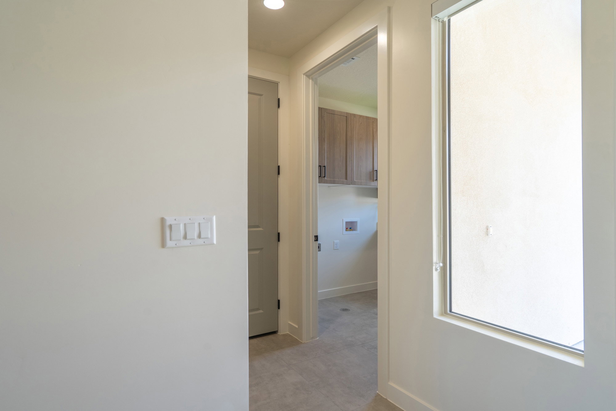 Hallway featuring light neutral wall paint and a modern window