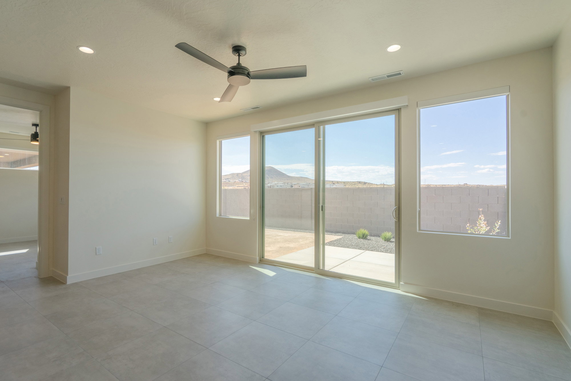Spacious room featuring light-toned tile flooring, recessed lighting, and a contemporary ceiling fan
