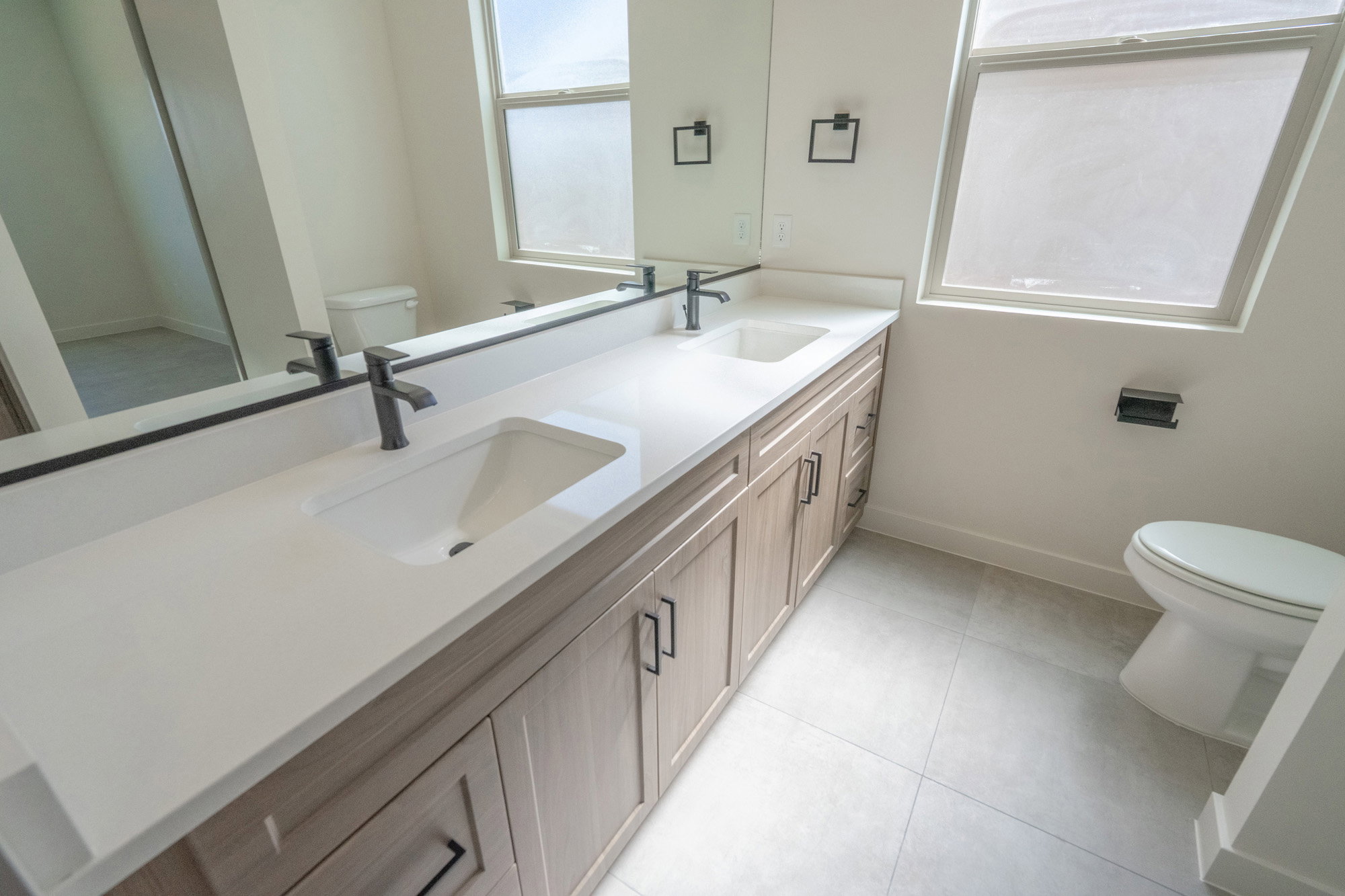 Dual vanity with integrated white rectangular sinks and matte black fixtures